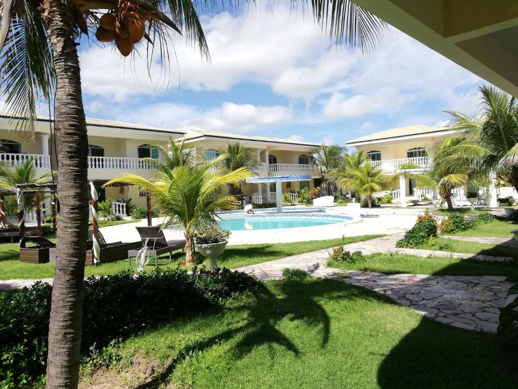 a view of a resort with a pool and palm trees at Apartamento 150m da praia de Canoa Quebrada in Canoa Quebrada