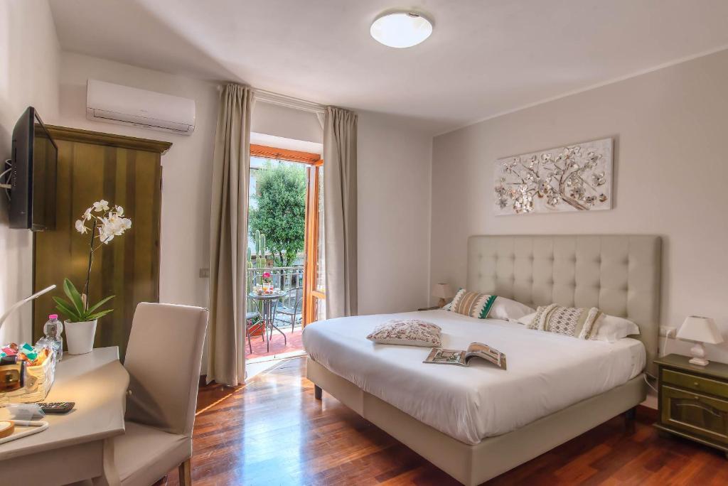 a bedroom with a bed and a table and a desk at Plaza Rooms Ciampino in Ciampino