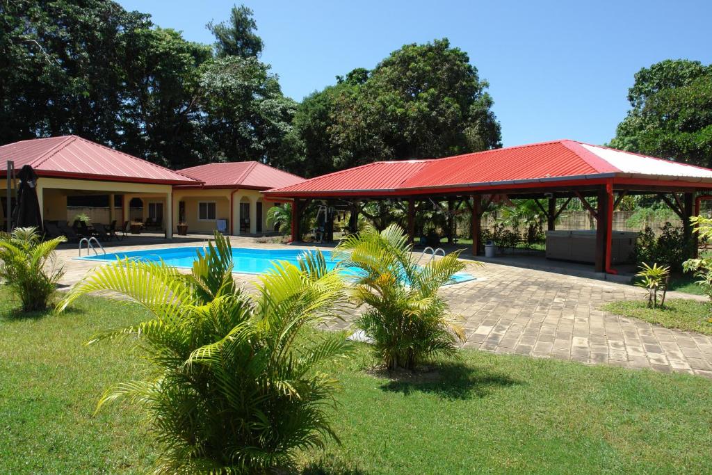 a resort with a swimming pool and a red roof at Kekemba Apartments Paramaribo in Paramaribo