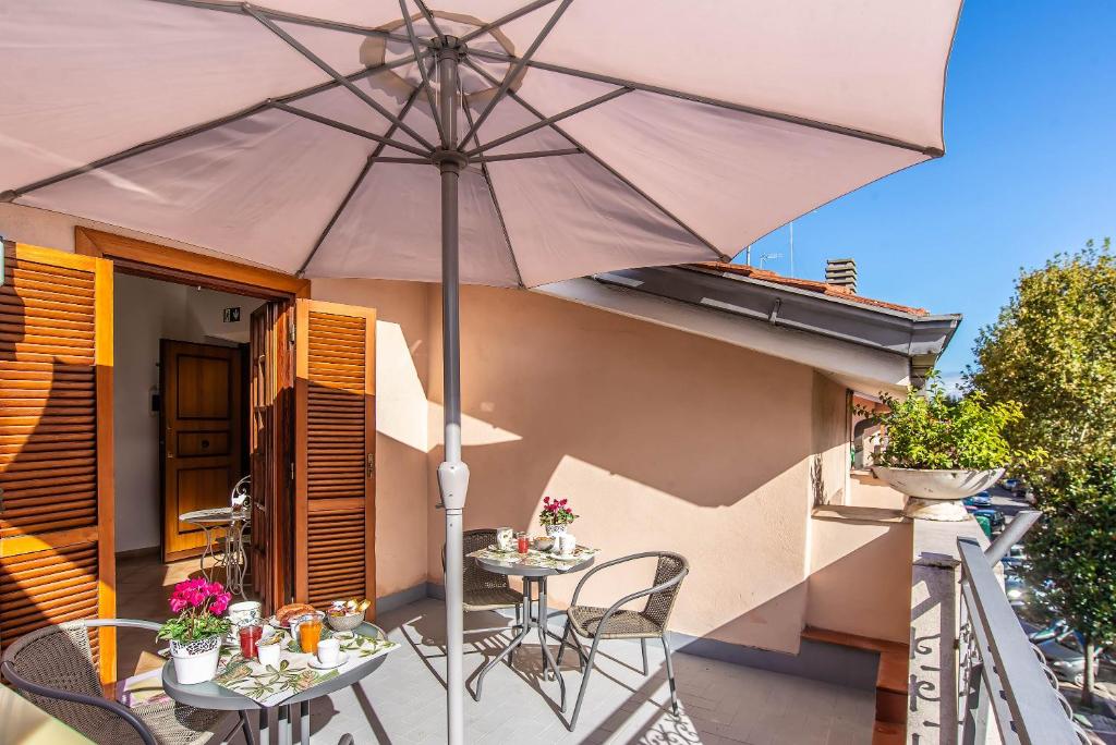 a patio with a table and chairs and an umbrella at Plaza Rooms Ciampino in Ciampino