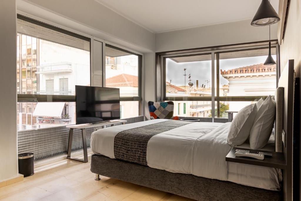 um quarto com uma cama grande e uma janela grande em BOUTiE Premium, a KalamataStay Property em Kalamata