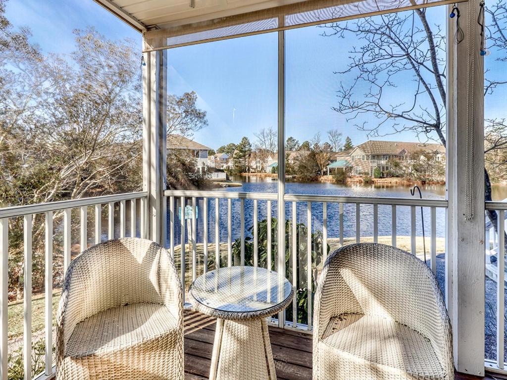 - une terrasse couverte avec 2 chaises, une table et une fenêtre dans l'établissement Sea Colony - Lakeshore, à Bethany Beach