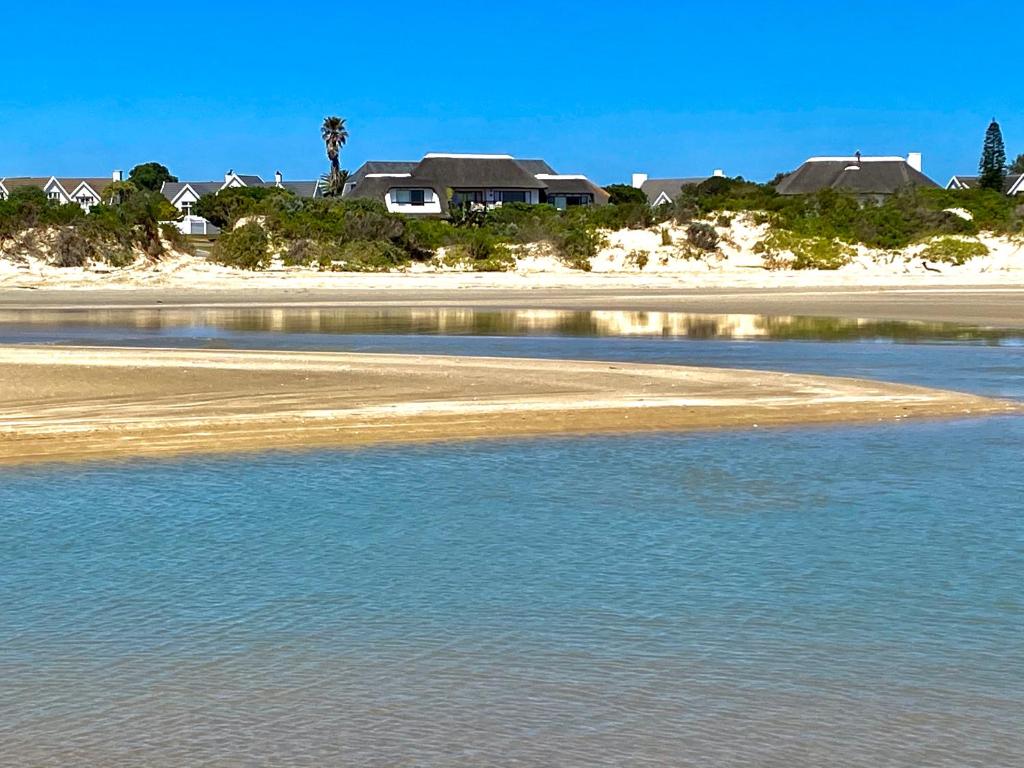 聖弗朗西斯灣的住宿－i-LOLLO Bed & Breakfast at the River Mouth，水体,有房子的背景