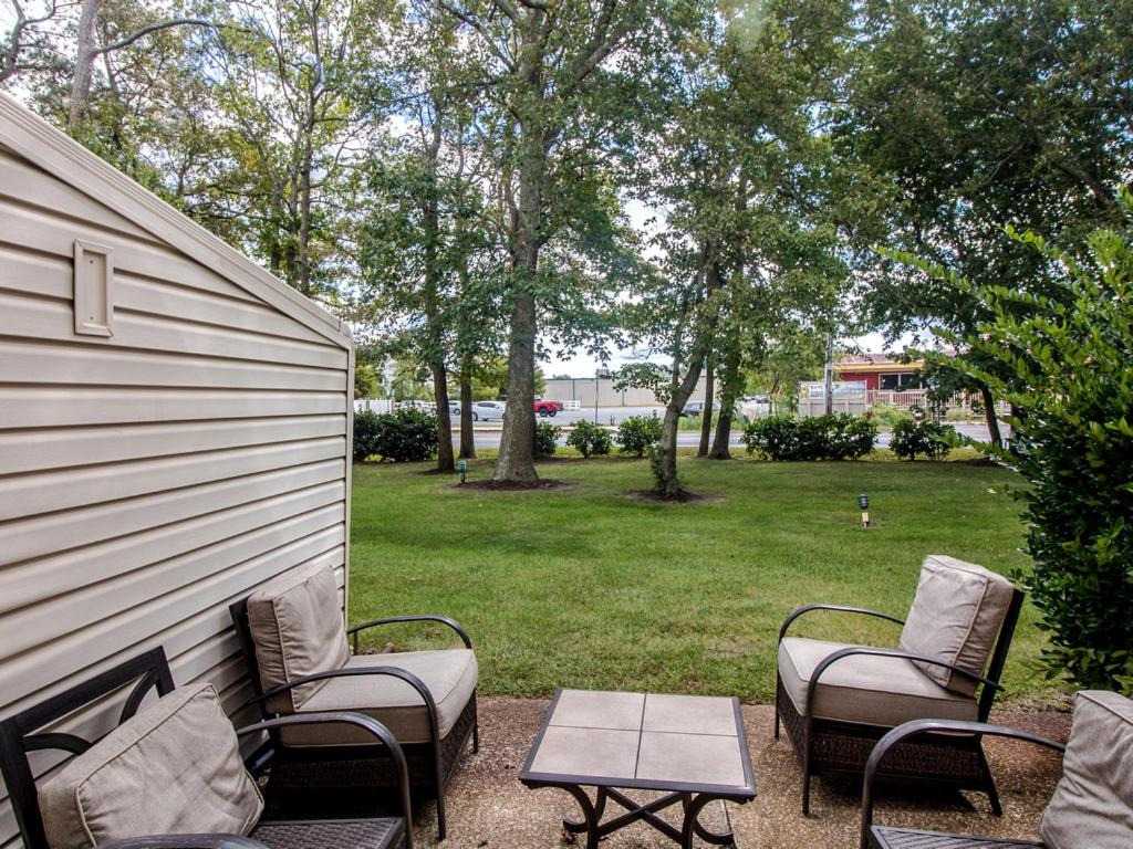 a patio with chairs and a table next to a yard at Sea Pines Village - 5 Sea Pines Village in Bethany Beach