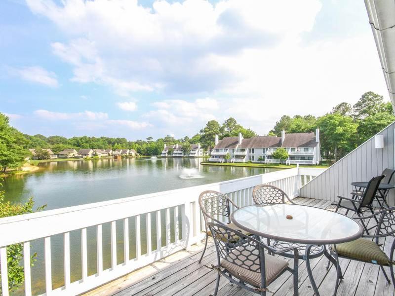 uma varanda com uma mesa e cadeiras e um rio em Sea Colony - 1007B West Lake em Bethany Beach