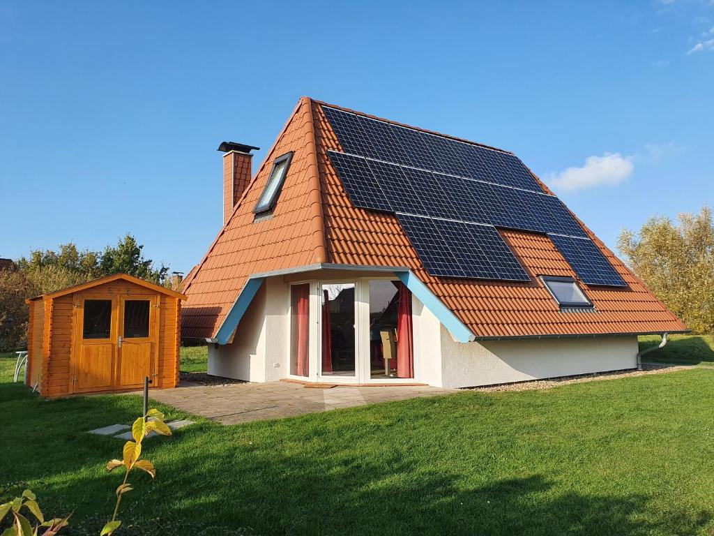 ein Haus mit Sonnenkollektoren auf dem Dach in der Unterkunft Ferienhaus Klapötke in Dorum Neufeld