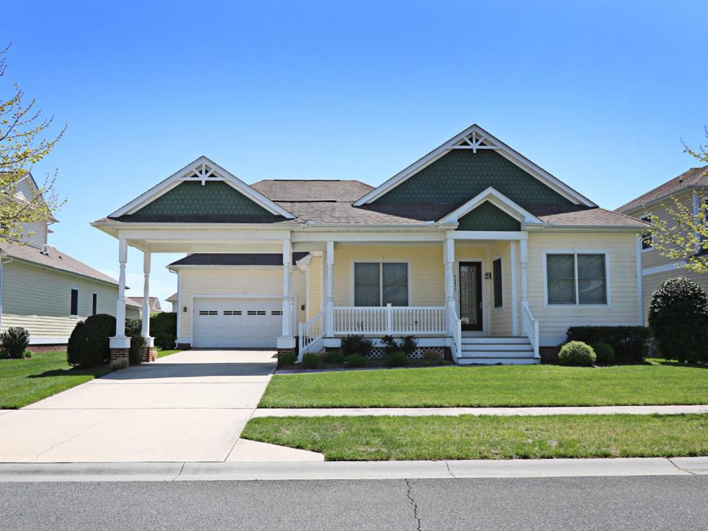a white house with a porch and a driveway at Bayside Resort - 36477 Wild Rose in Selbyville