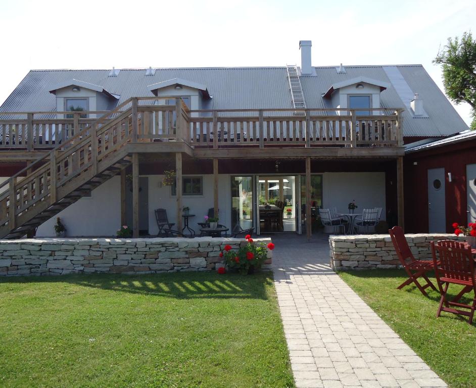 a large house with a deck and a patio at Ljungs Fem Rum in Västergarn