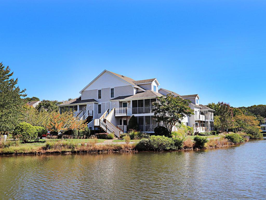 a large house next to a body of water at Sea Colony - 55037 Pine Lake in Bethany Beach