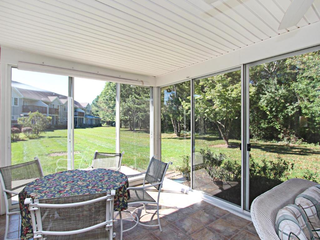 un porche cubierto con mesa y sillas en Sea Colony - 56010 Pine Shore, en Bethany Beach