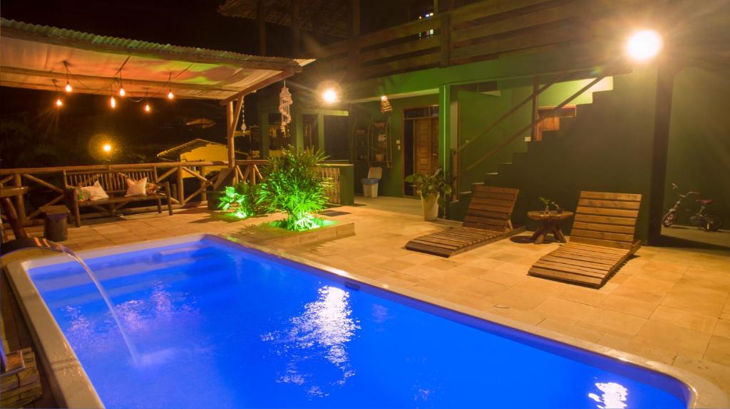 - une piscine avec 2 chaises et une terrasse dans l'établissement Pousada Bicho Preguiça, à Itacaré