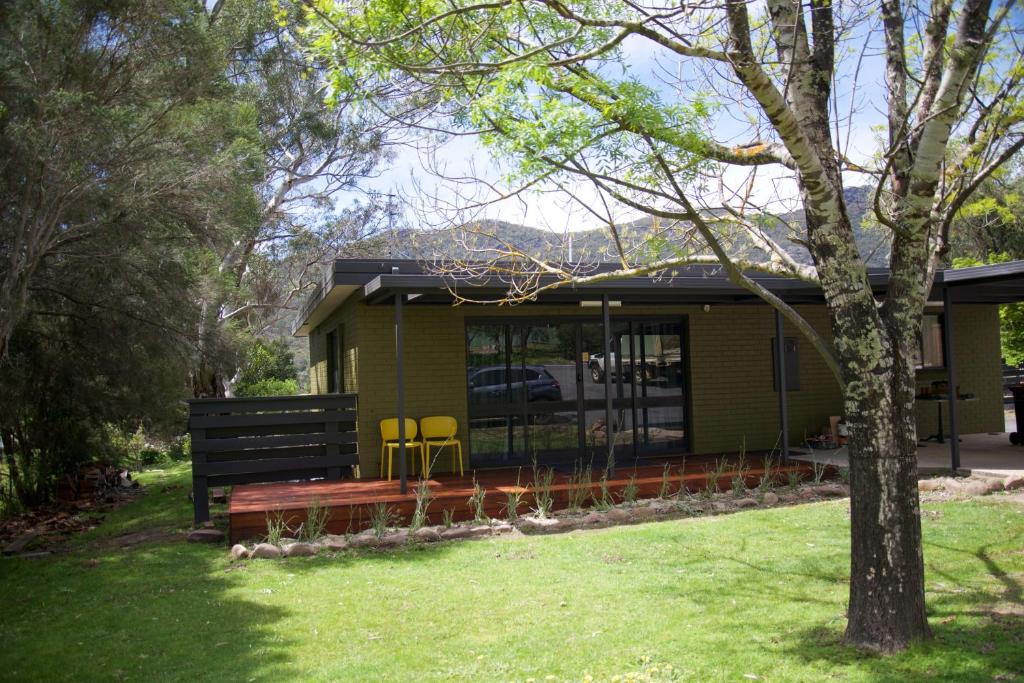a green house with a bench in the yard at 151 Grampians Road in Halls Gap
