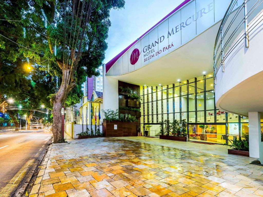 a building with a tree in front of a street at Grand Mercure Belem do Para in Belém