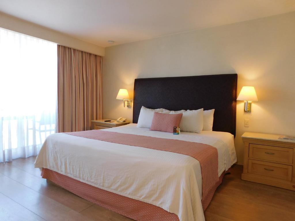 Habitación de hotel con cama grande y ventana en Hotel Palacio Azteca en Tijuana