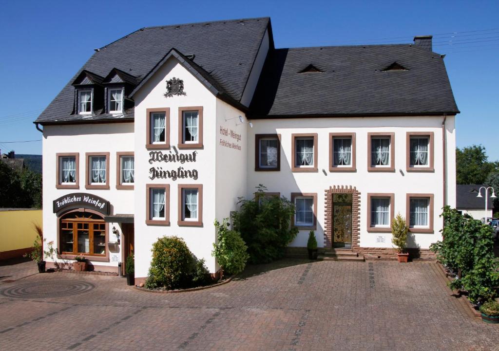 a white building with a black roof at Gästehaus Weingut - Fröhliches Weinfass in Kenn