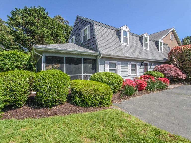 a house with bushes in front of a driveway at Kent Condo - 39260 Retreat in Bethany Beach