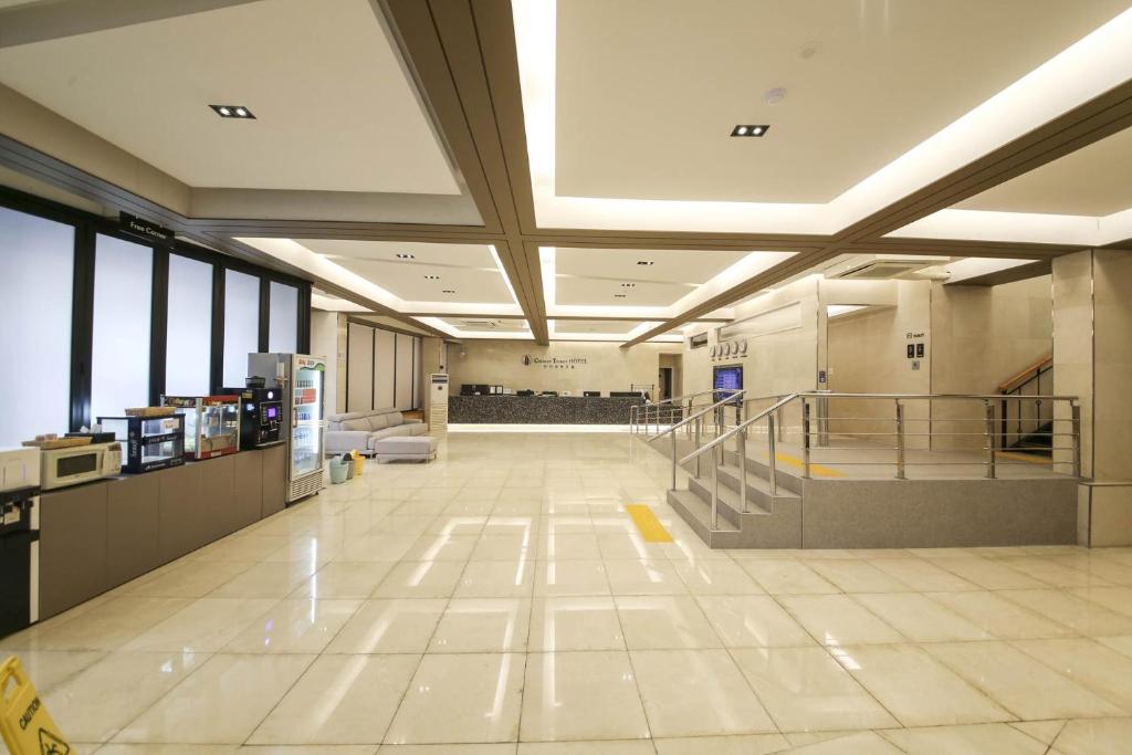 a large lobby with a staircase in a building at Benikea hotel in Cheonan