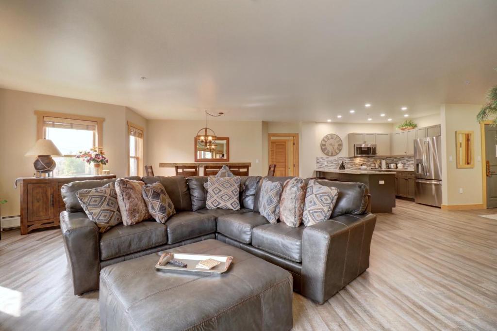 a living room with a leather couch and a kitchen at Cs302 Copper Springs Condo in Copper Mountain