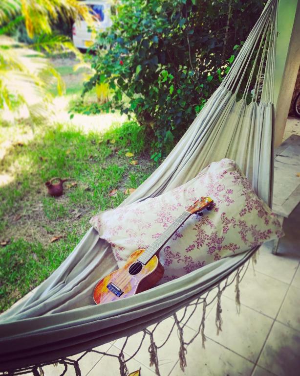 a hammock with a guitar and a pillow on it at イリワ -stay&coffee iriwa- in Ishigaki Island