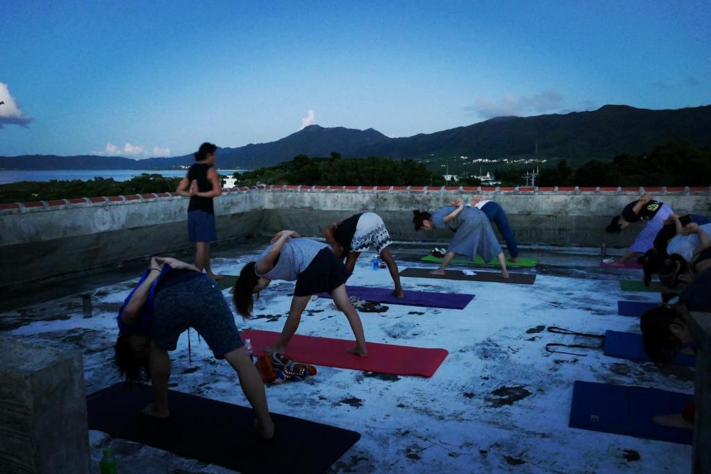 a group of people doing yoga on a wall at イリワ -stay&coffee iriwa- in Ishigaki Island