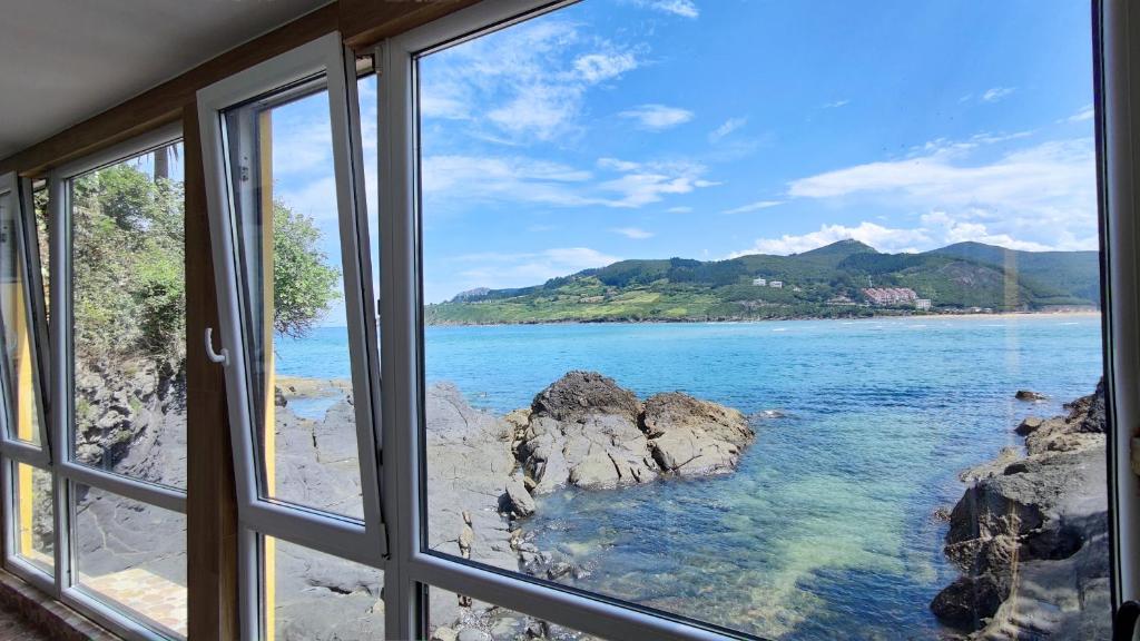 ein Fenster mit Meerblick von einem Haus in der Unterkunft Mundaka Sea Flat in Mundaka