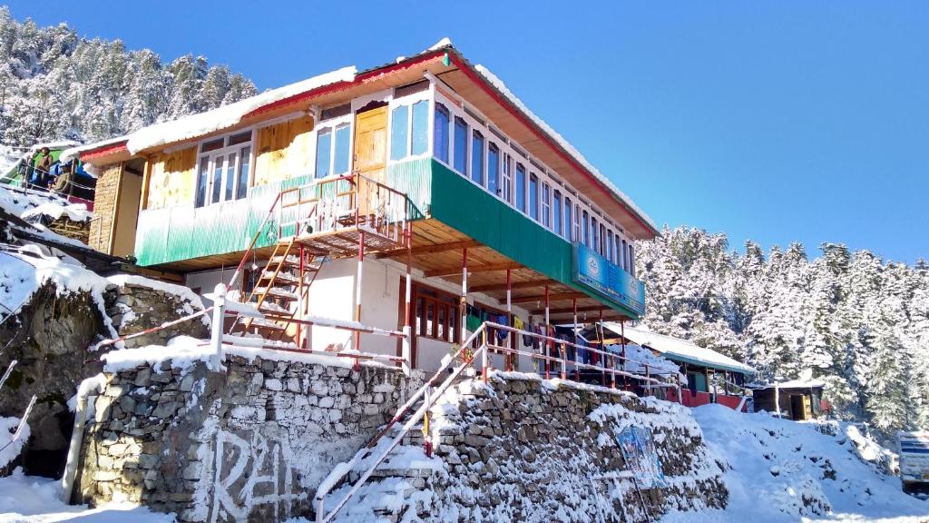 a house on top of a snow covered mountain at Himalayan High Trekkers Lodge - Sankri in Sankri