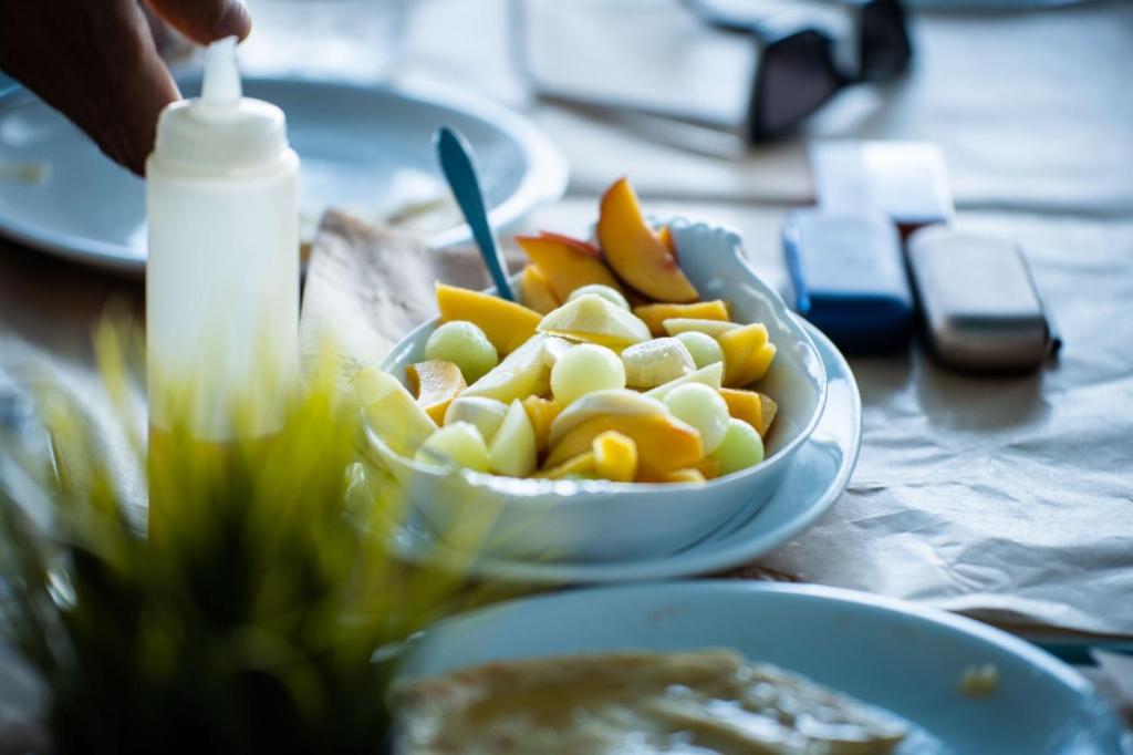 a bowl of fruit and a bowl of food on a table at Livikon by the Sea in Hora Sfakion