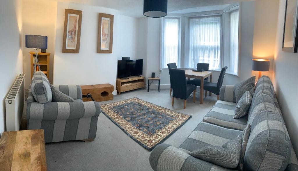 a living room with two couches and a table at Comfy flat in the heart of St Leonards in St. Leonards