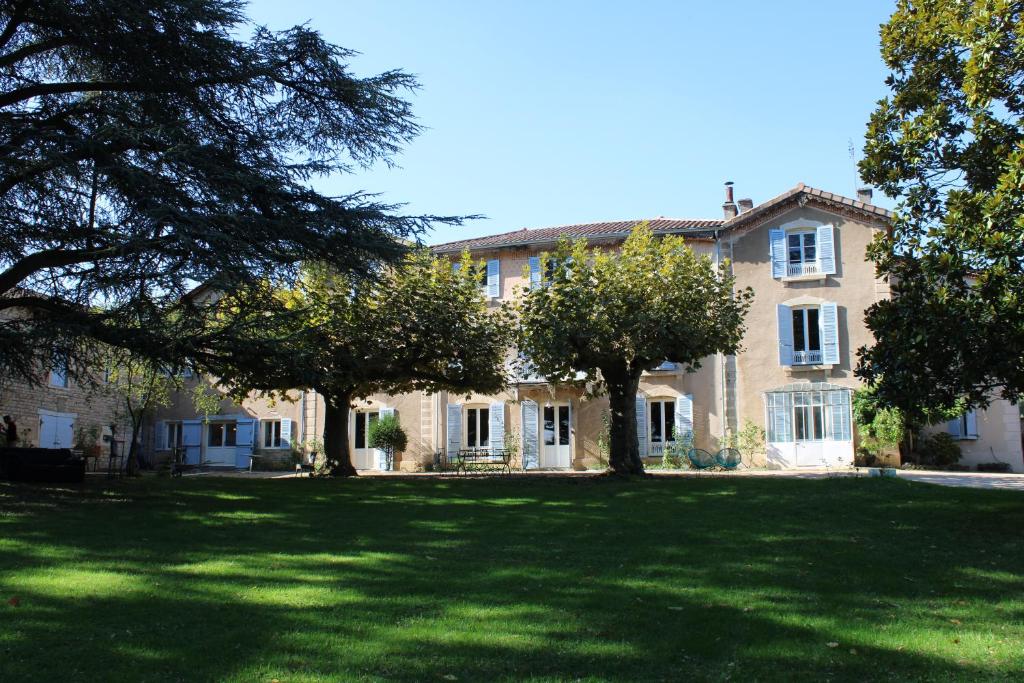 une grande maison avec des arbres devant elle dans l'établissement Clos Ceres, à Viré