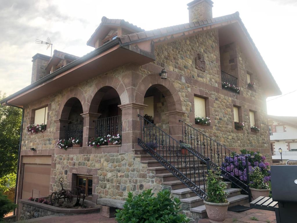 QuijasにあるVilla La Encinaの階段と花の大きな石造りの建物