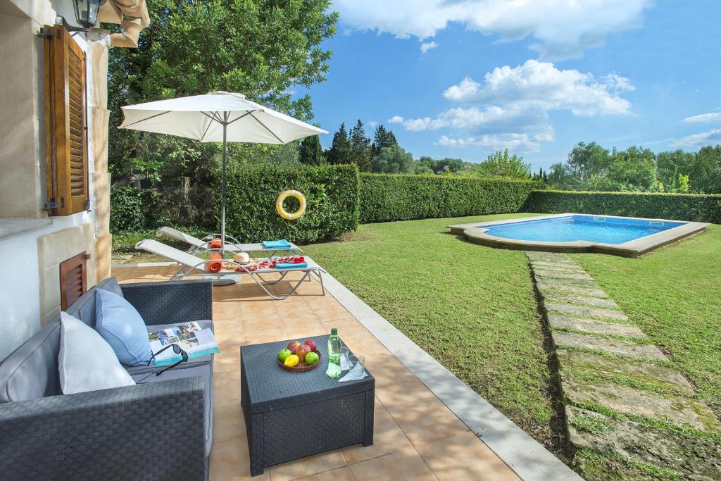 een achtertuin met een zwembad en een parasol bij Owl Booking Villa Tarongers - Stay For Couples in El Port