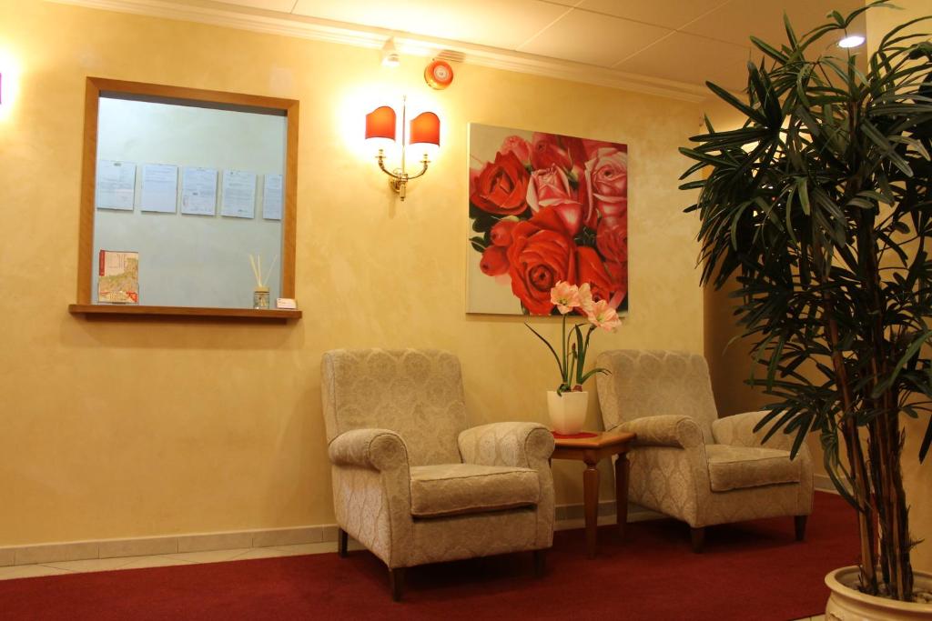 a waiting room with two chairs and a mirror at Hotel Vitti in Borghesiana 