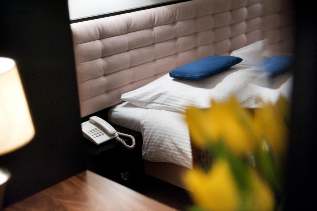 a bedroom with a bed with a blue pillow on it at Hotel Focus in Lublin