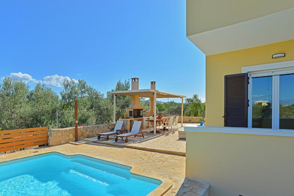 ein Haus mit einem Pool und einer Terrasse in der Unterkunft VILLA KONSTANTINOS 6 bedrooms in Ägina Stadt