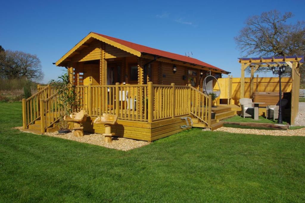 a small wooden cabin with a gazebo at Balmoral Studio Lodge in Ellesmere