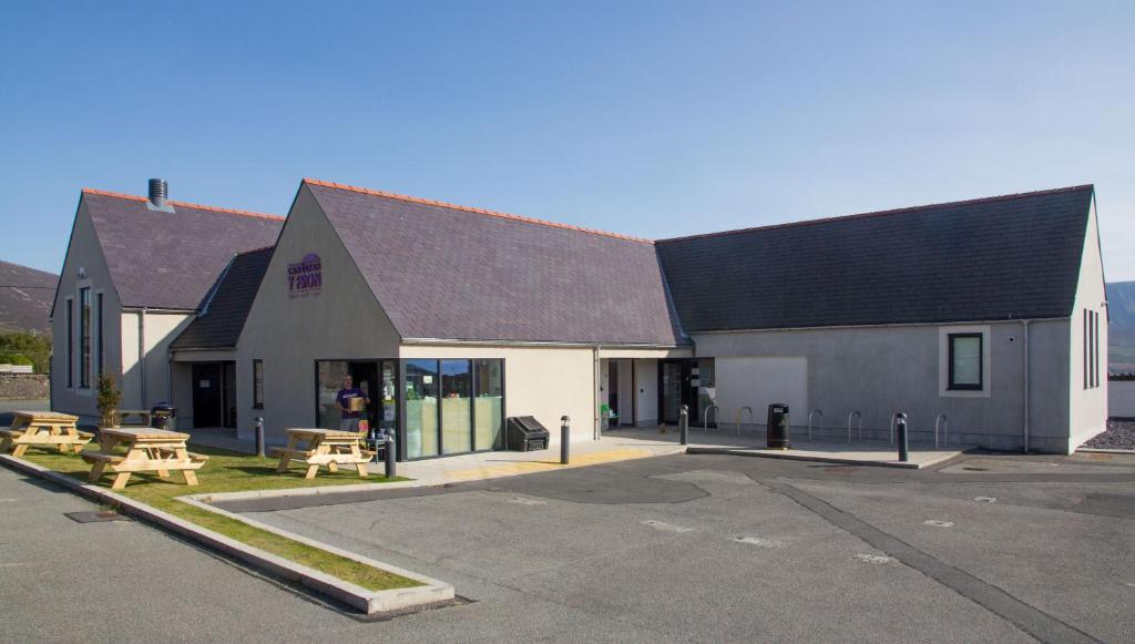 un edificio con una mesa de picnic en un aparcamiento en Canolfan Y Fron en Caernarfon