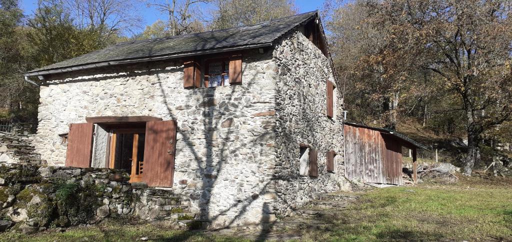 an old stone building with wooden doors and windows at Grange ancienne aménagée in Rabat-les-Trois-Seigneurs