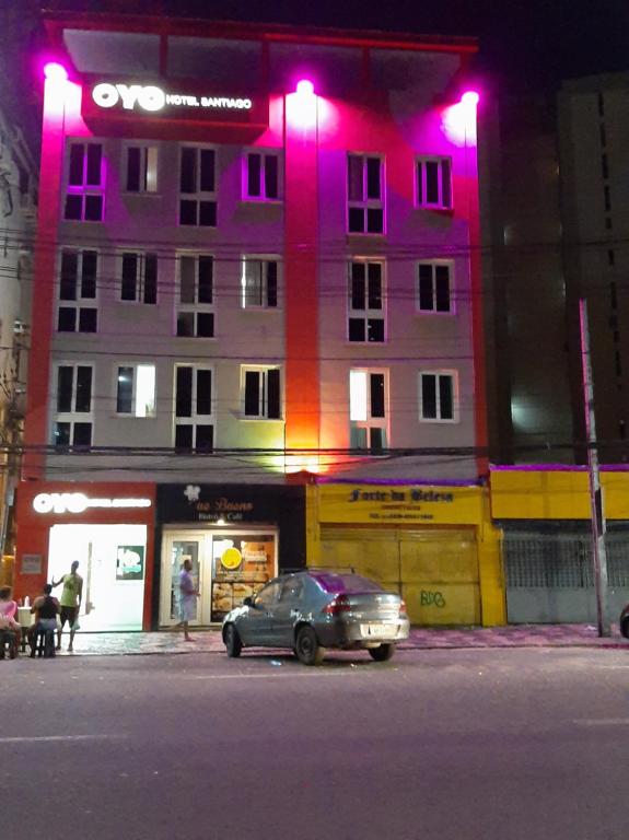 a car parked in front of a building with pink lights at Hotel Santiago in Salvador
