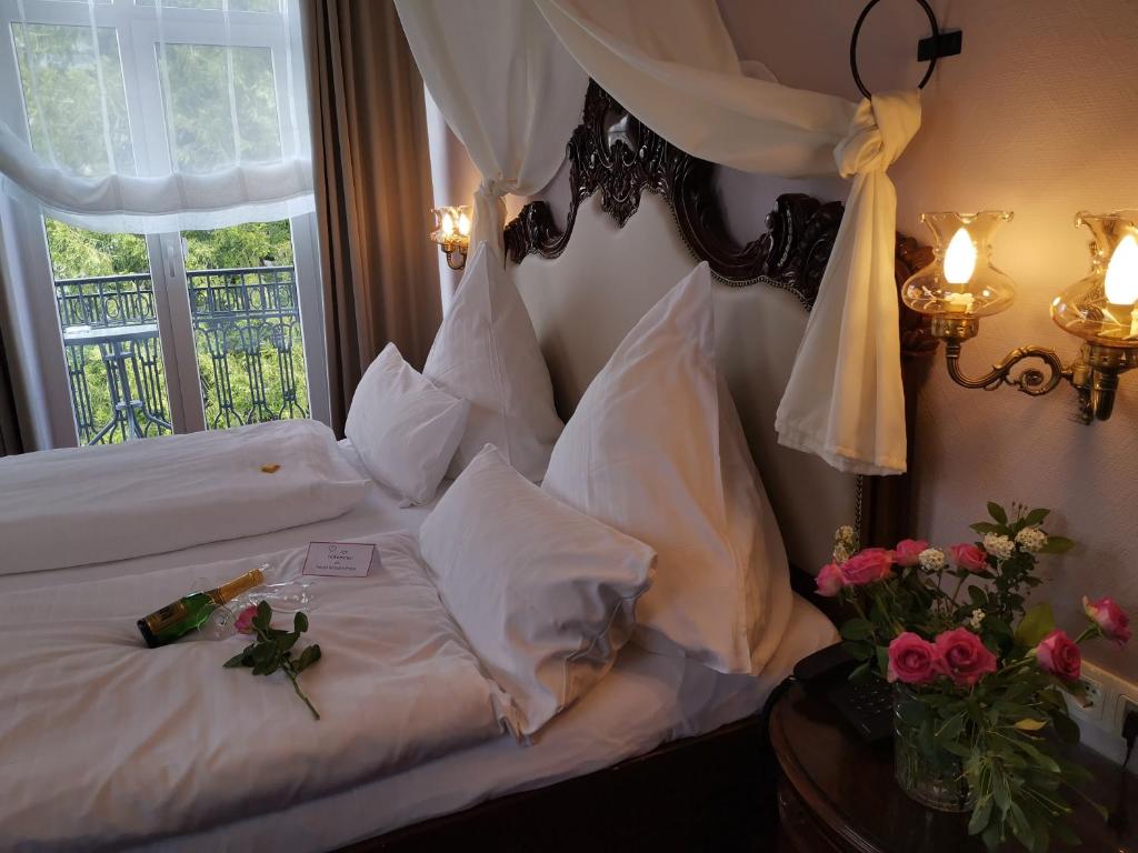 Hotel Weisses Haus في باد كيسينغن: غرفة نوم بسرير وملاءات بيضاء ونافذة