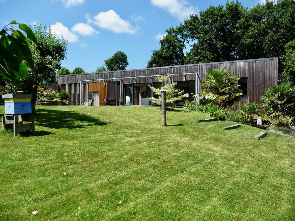 uma casa com um relvado verde em frente em La Miellerie em Lannion