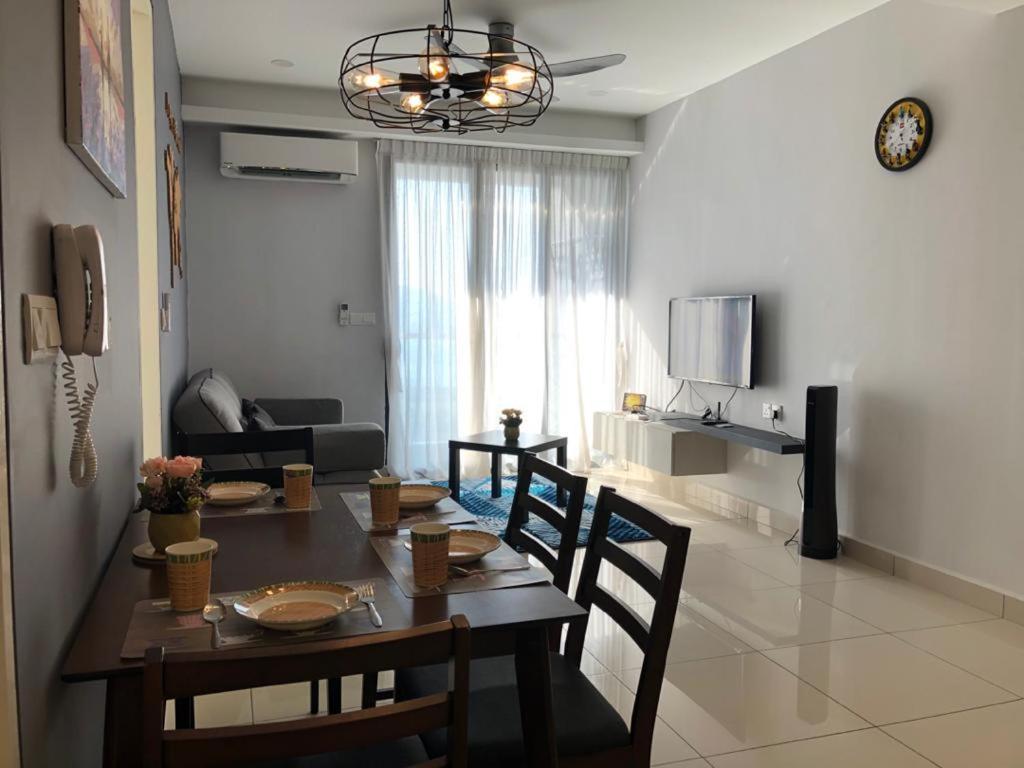 a dining room table and chairs in a living room at Woodsbury Homestay Butterworth in Butterworth