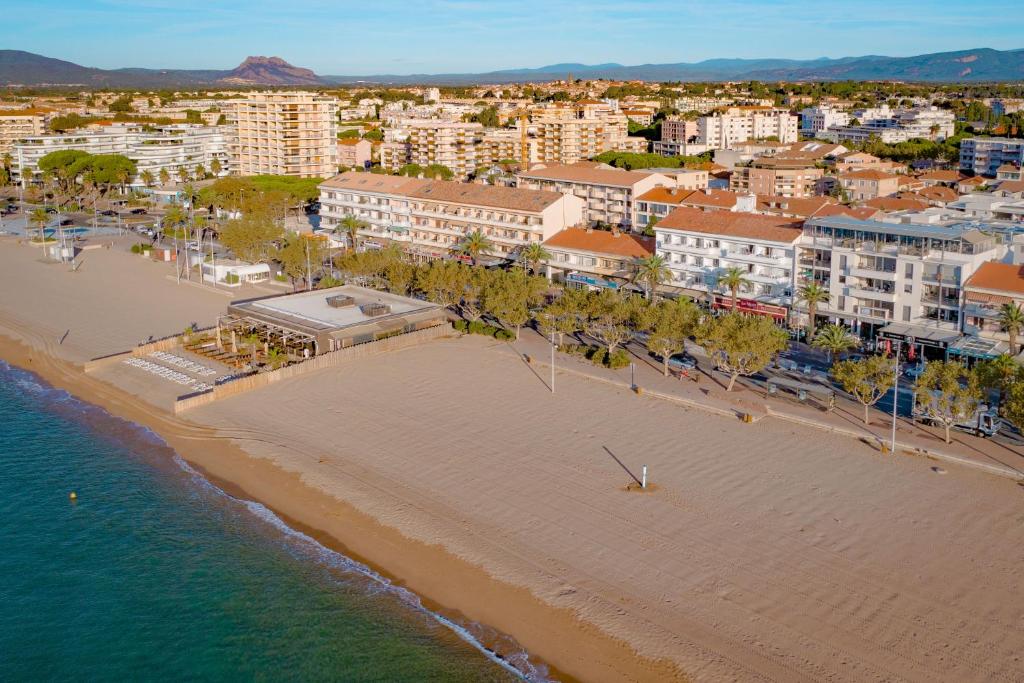 an aerial view of a beach with buildings and the ocean at Les Palmiers in Fréjus