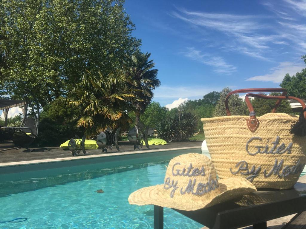 a basket sitting on a bench next to a swimming pool at Gîtes By Medoc in Bégadan