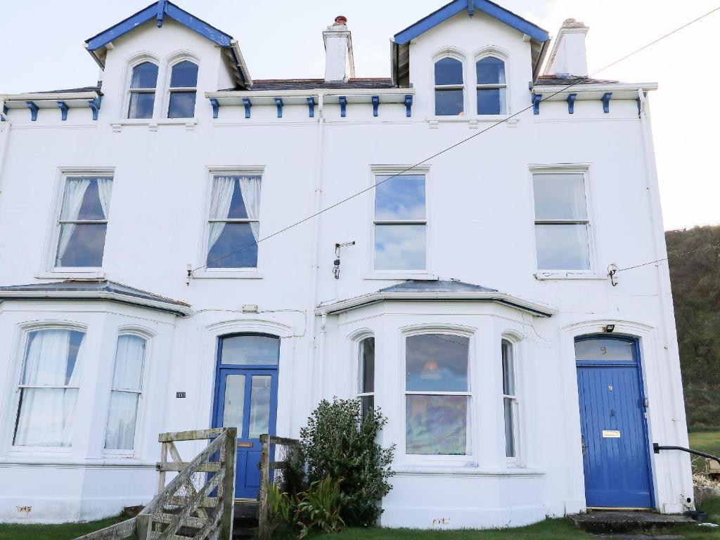 an old white house with a blue door at Carriguisnagh in Ballycastle