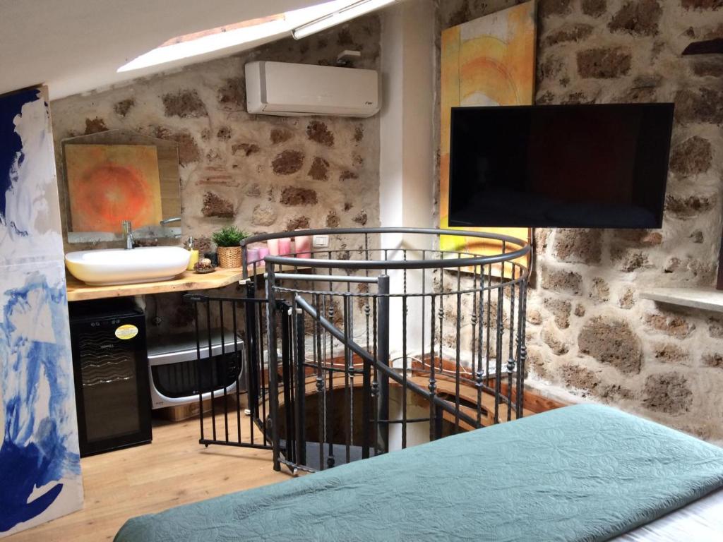 a room with a sink and a desk with a television at Abbracci Home Barbarano in Barbarano Romano