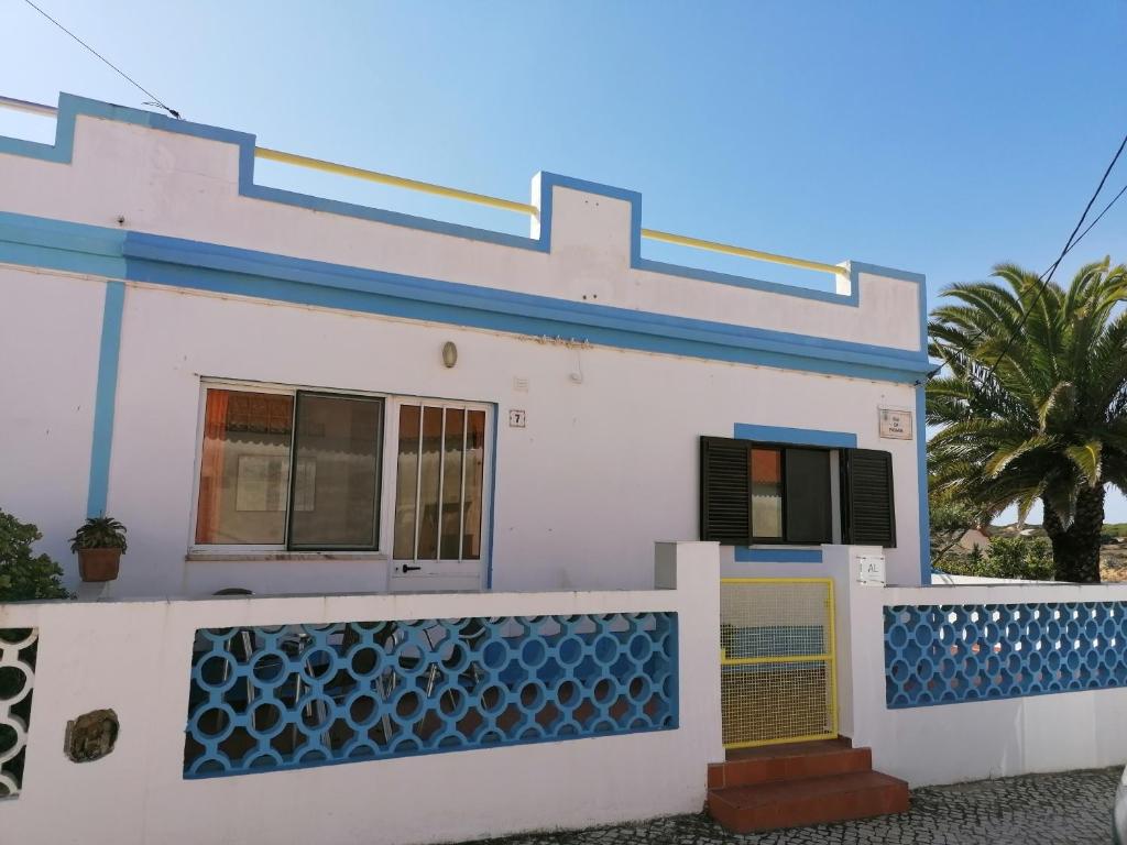 uma casa branca com acabamento azul e uma cerca em Casa do Lado na Carrapateira