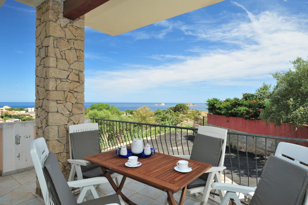 un tavolo e sedie su un balcone con vista sull'oceano di 2 bedrooms apartement at santa Maria Navarrese Baunei 500 m away from the beach with wifi a Santa Maria Navarrese