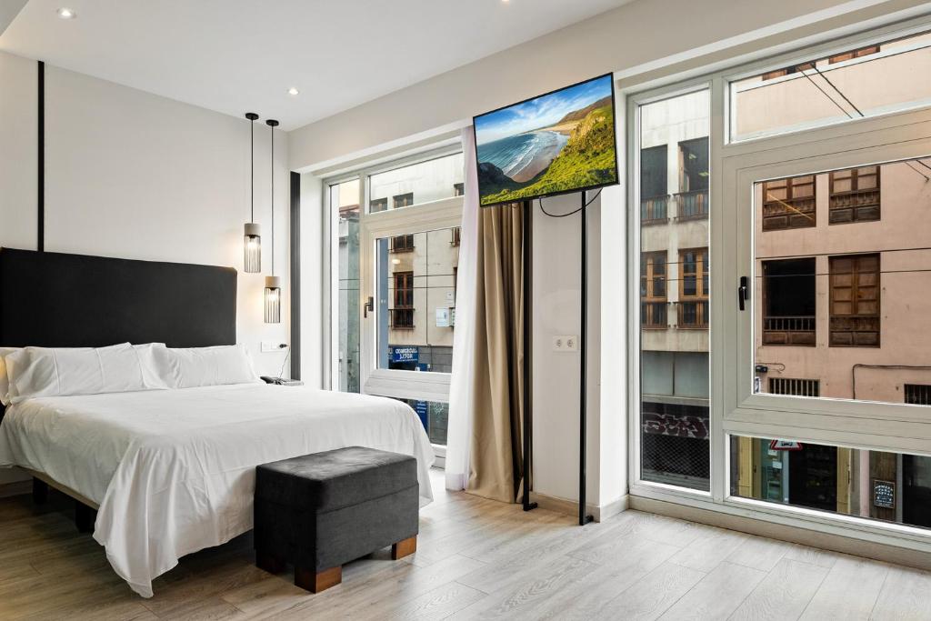 a bedroom with a bed and large windows at Urban Anaga Hotel in Santa Cruz de Tenerife