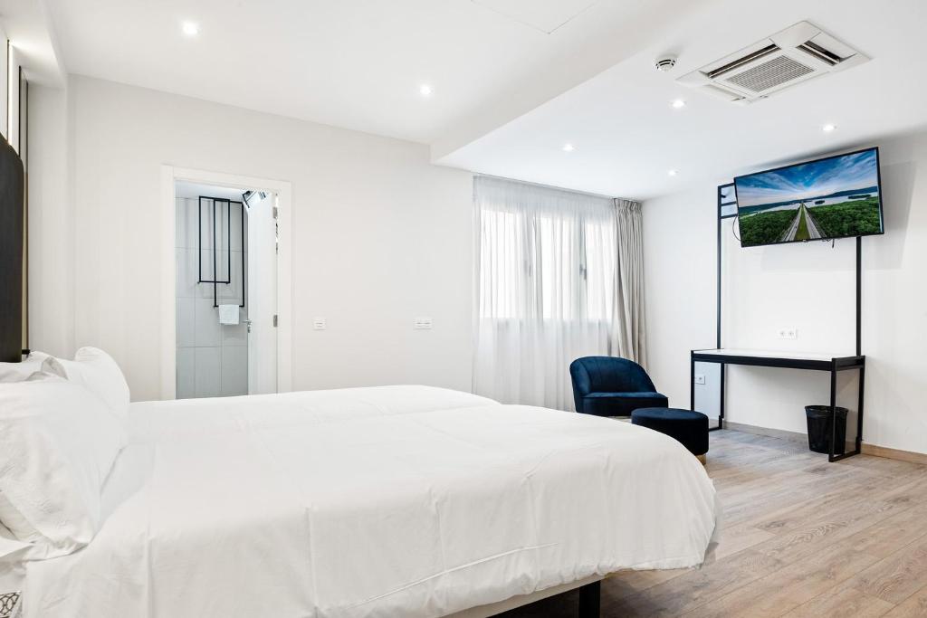 a white bedroom with a white bed and a desk at Urban Anaga Hotel in Santa Cruz de Tenerife