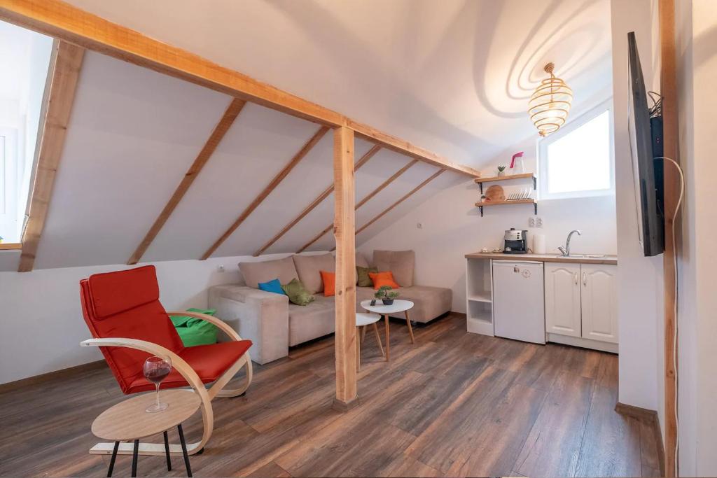 ein Wohnzimmer mit einem roten Stuhl und einem Sofa in der Unterkunft Entire Central House with Garden - 7 rooms, 5 bedrooms, 3 Baths in Sofia